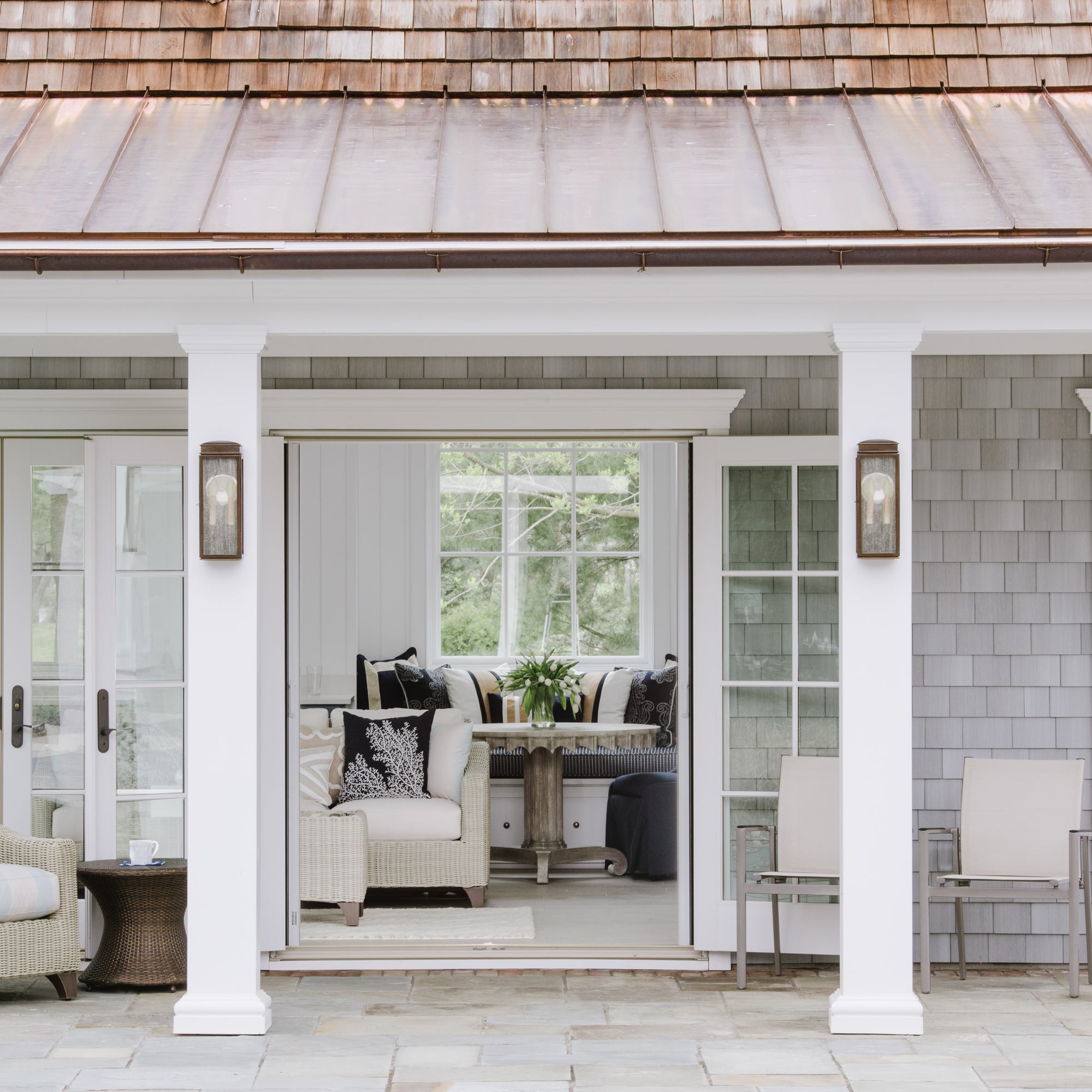 View into a sophisticated pool house with neutral furnishings and navy accents. Interior design by Jamie Merida Interiors.