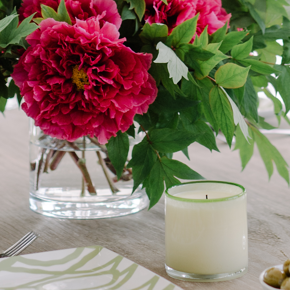 Gifts at Bountiful Home - ivory candle with green rim in front of a vase of tree peonies