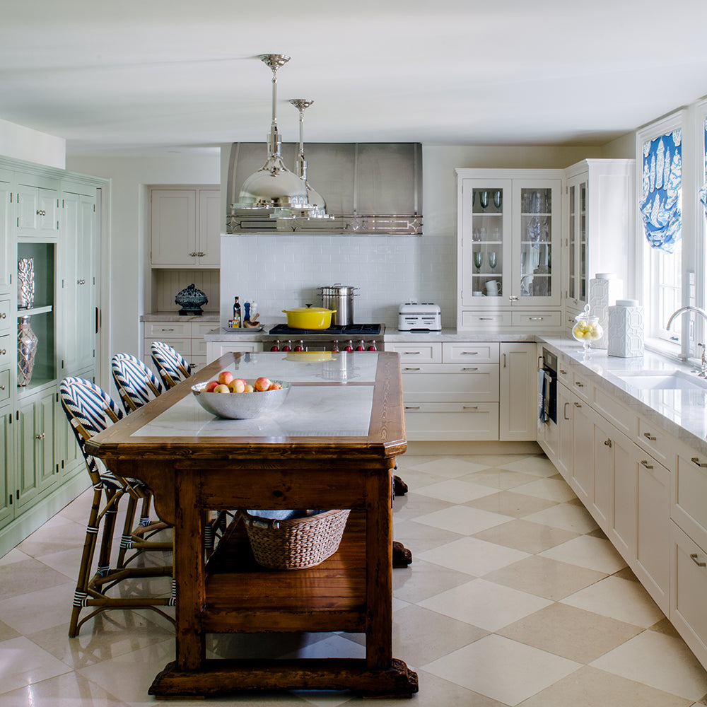 Kitchen design from Jamie Merida Interiors. Pictures green and white cabinets with a wood island and chrome finishes