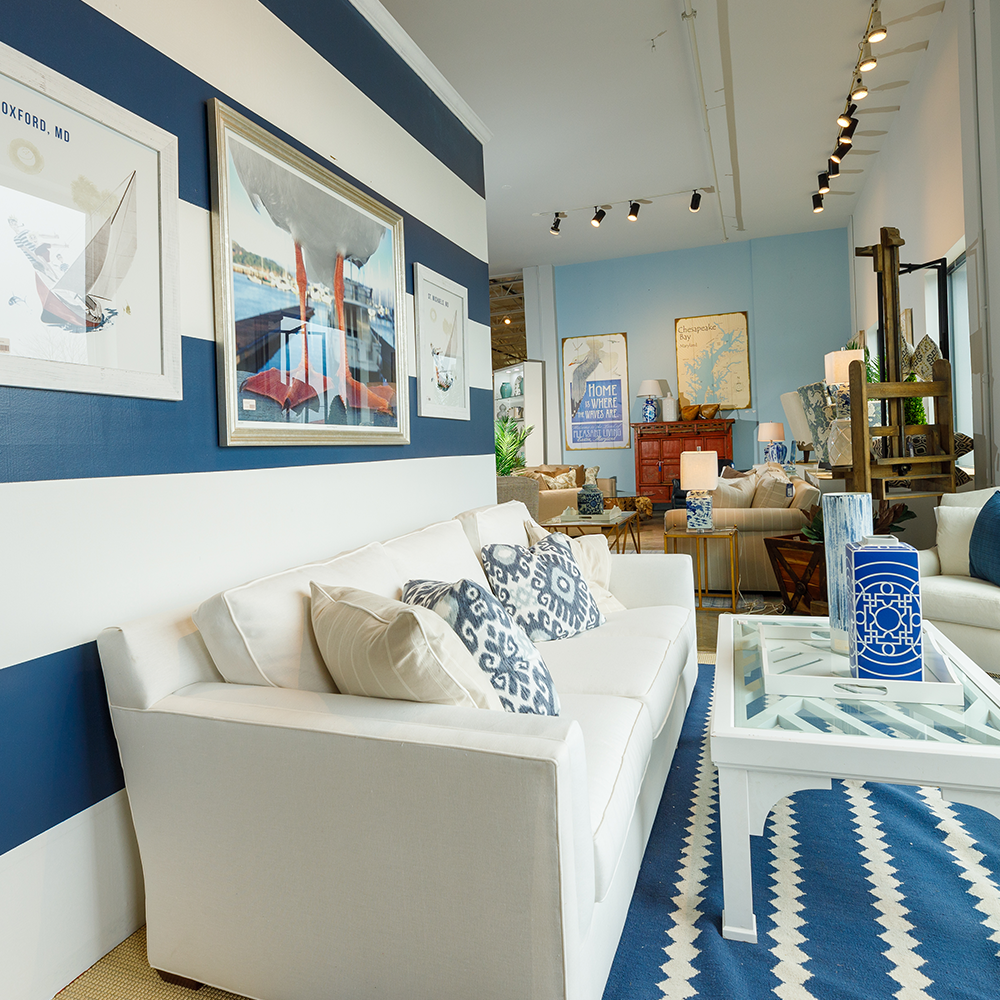 Bountiful Home store window - interior look at the window display - white couch with blue and white rug and striped wall